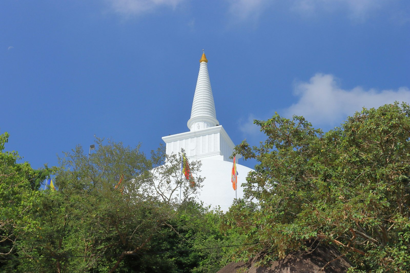White stupa rising above the sacred hill setting of Mihintale in Sri Lanka.
