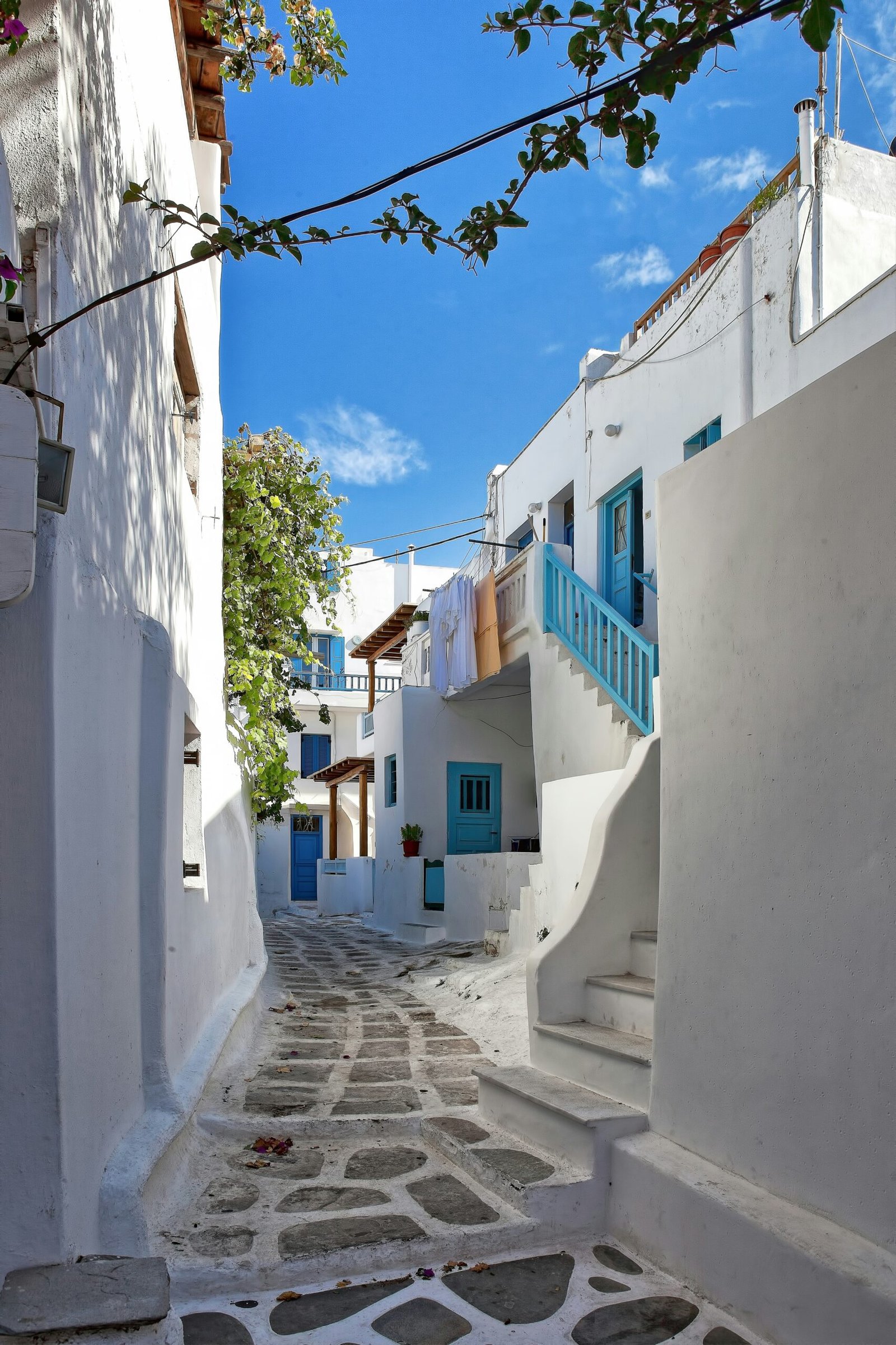 Whitewashed house and stone steps in Mykonos, creating a quiet island setting for a peaceful Greece retreat.