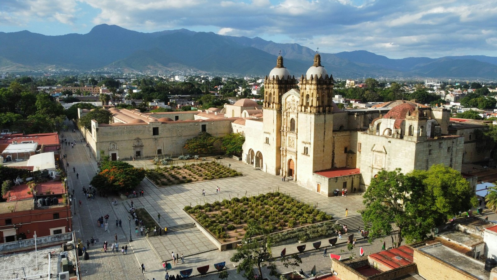 Main square and cathedral in Oaxaca, Mexico, with people walking through the courtyard