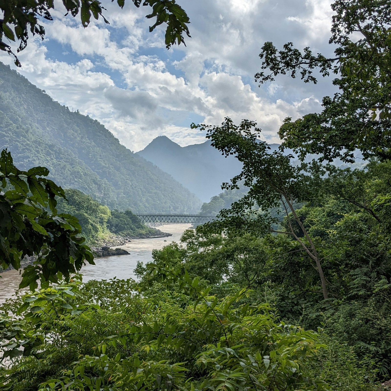 Rain-fed river cutting through the green hills of Rishikesh, matching the fresh and meditative atmosphere of India’s August retreat season.