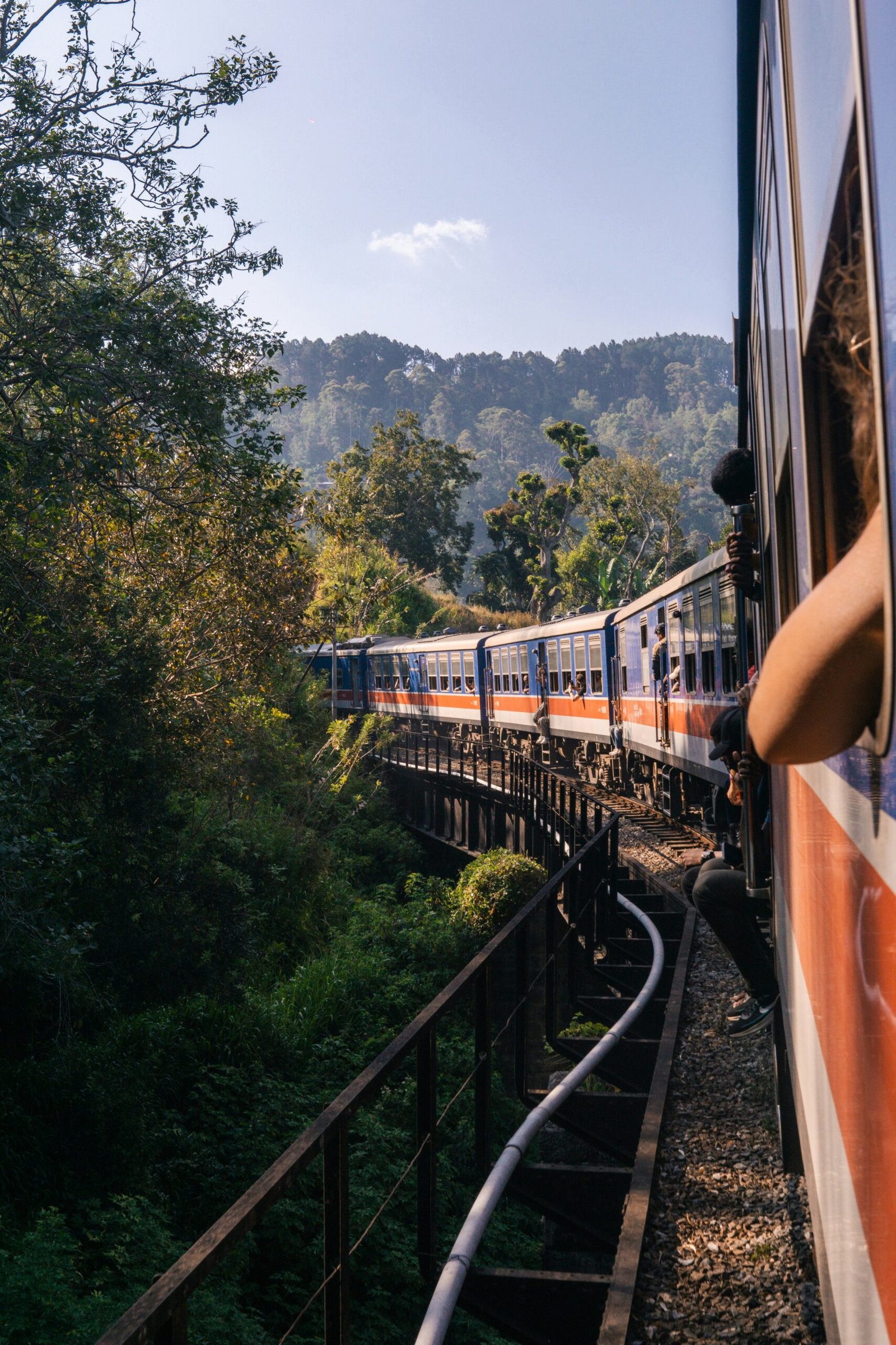Train moving through the green hills of Ella, Sri Lanka, capturing the grounded and immersive feeling of a hill-country retreat.