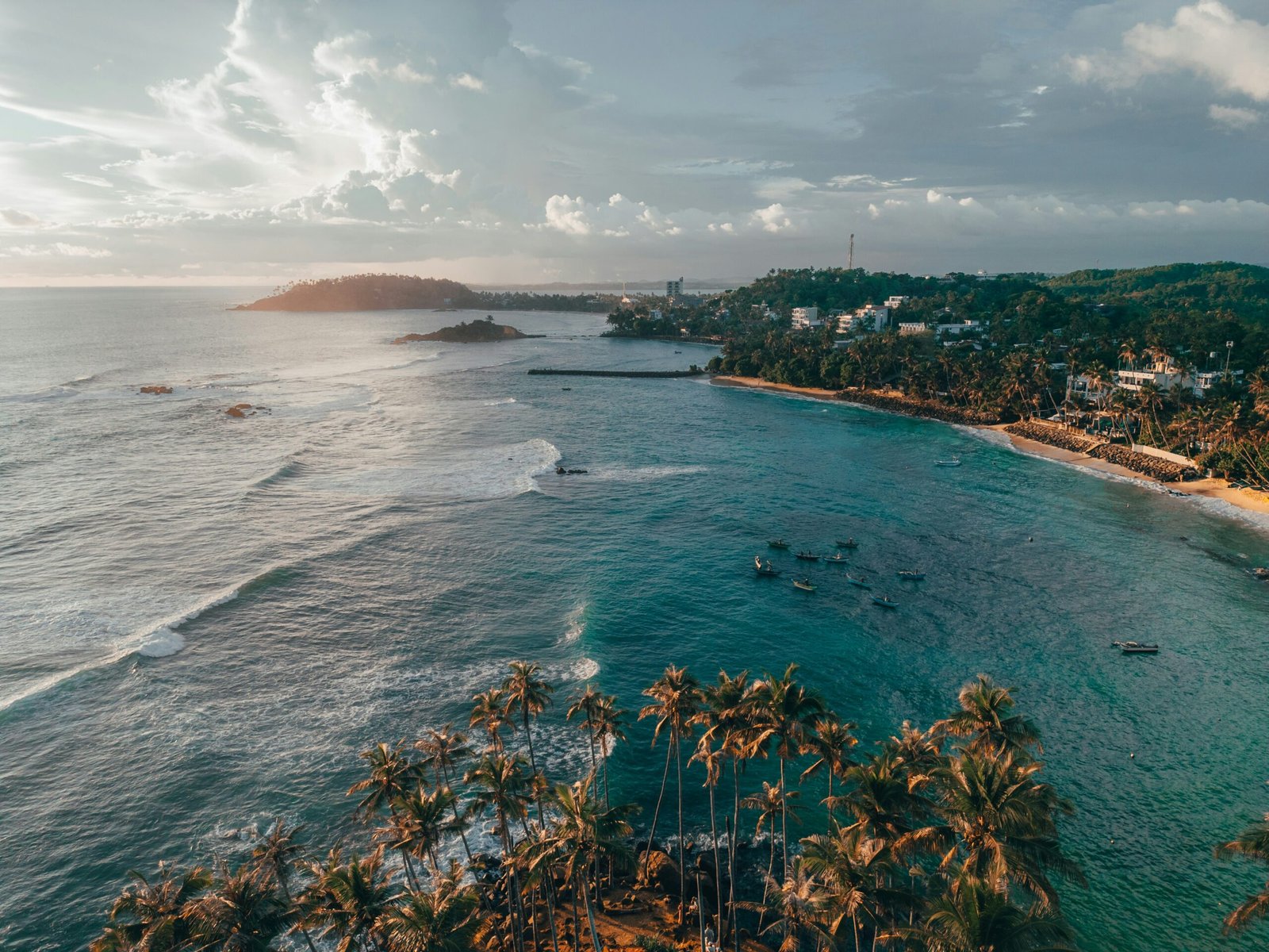 Aerial view of Mirissa Beach in Sri Lanka, capturing the sunny coastal atmosphere of a winter retreat focused on movement and renewal.