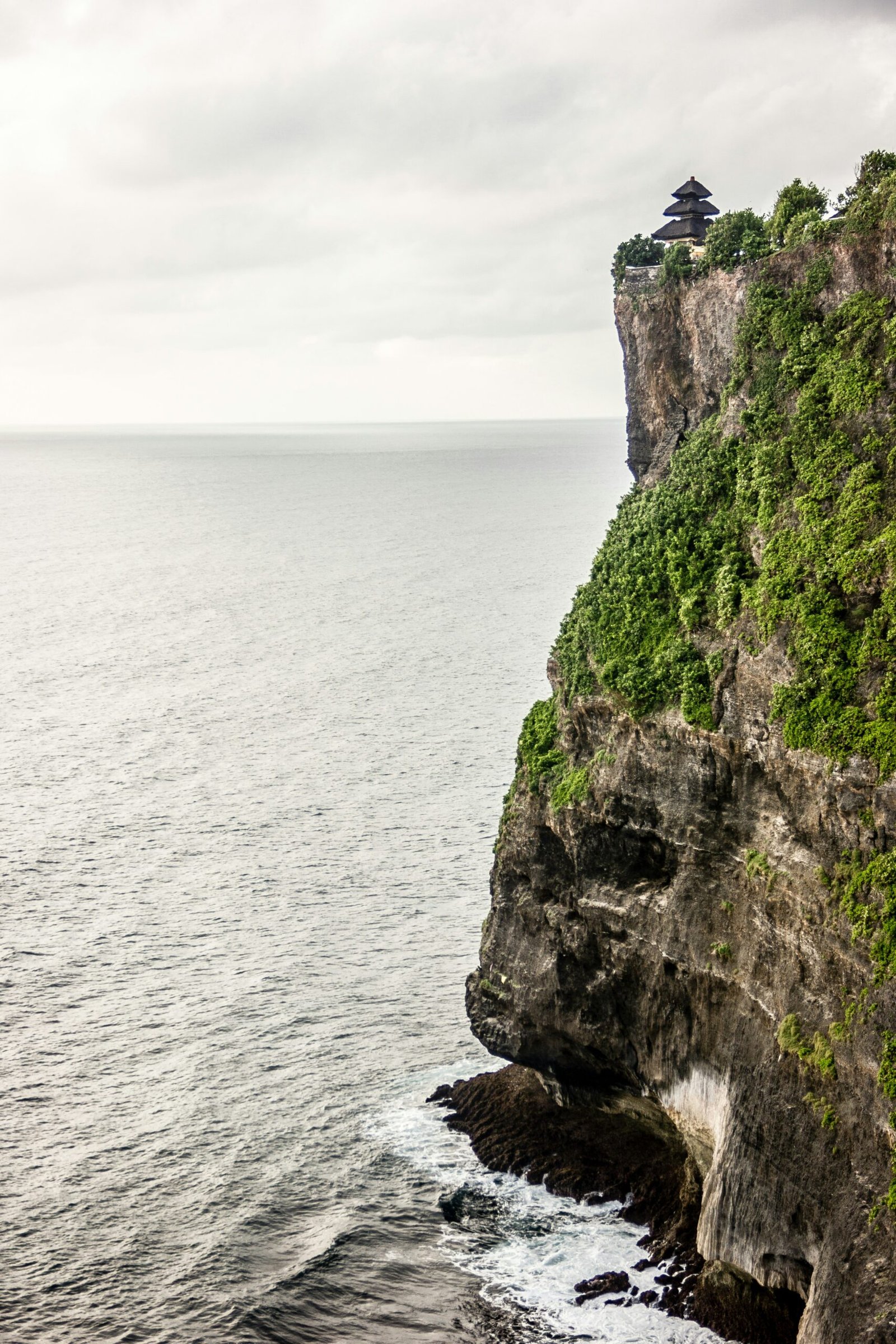 uluwatu temple on dramatic cliffs above the ocean in clear may weather