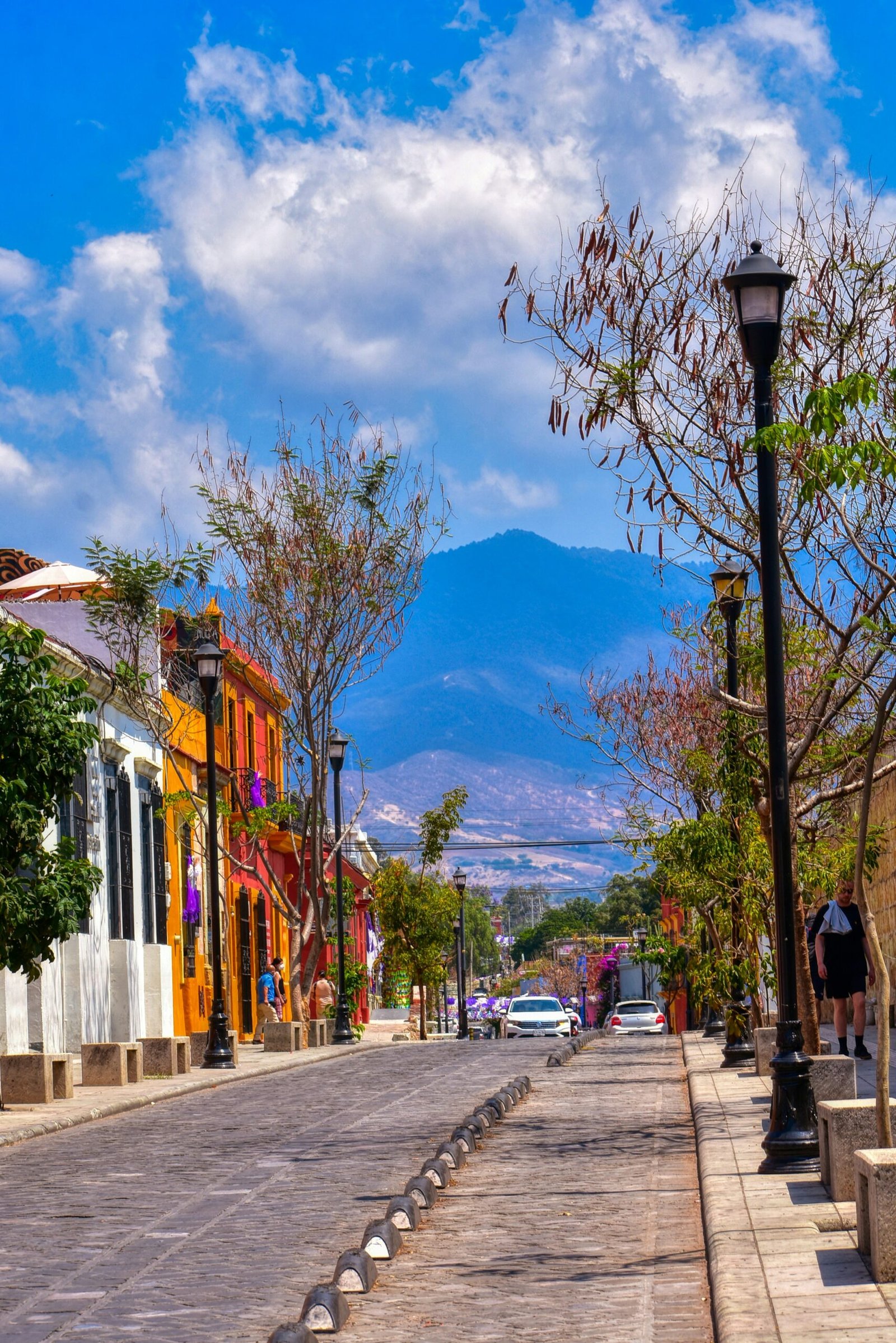 Colorful street in Oaxaca with mountain views and a relaxed cultural atmosphere for a Mexico retreat.