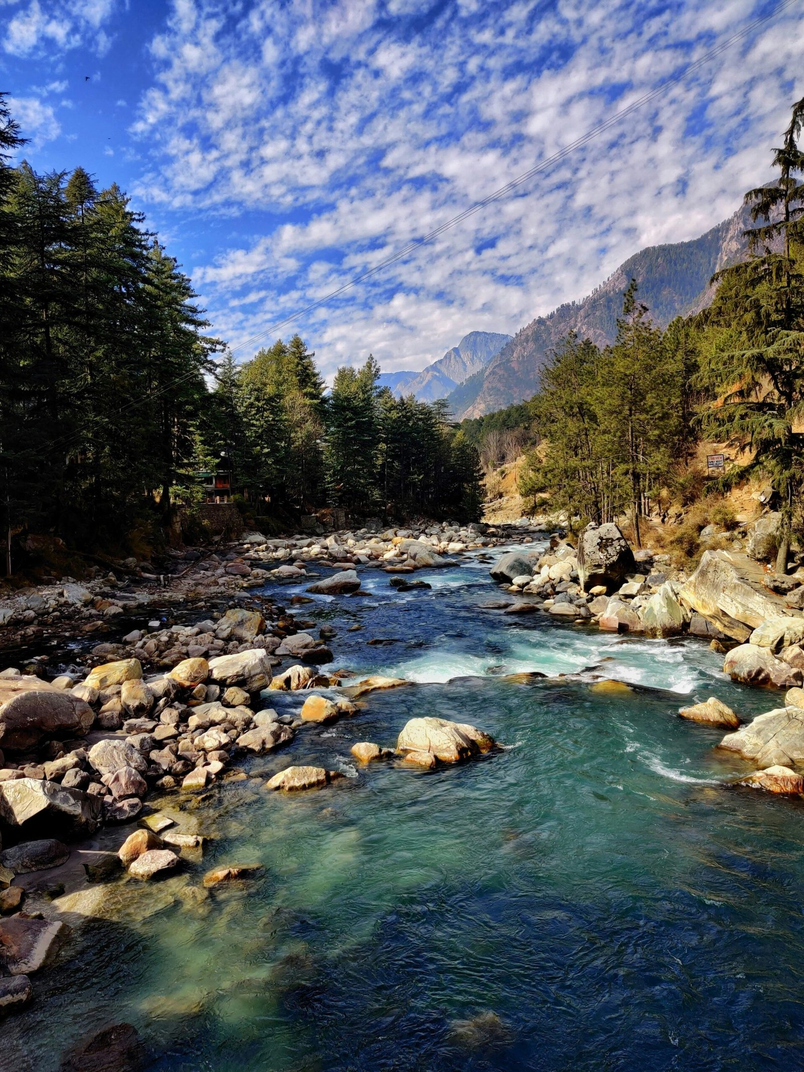 Mountain river winding through dense greenery, evoking the cleansing, grounded atmosphere of a retreat immersed in nature.