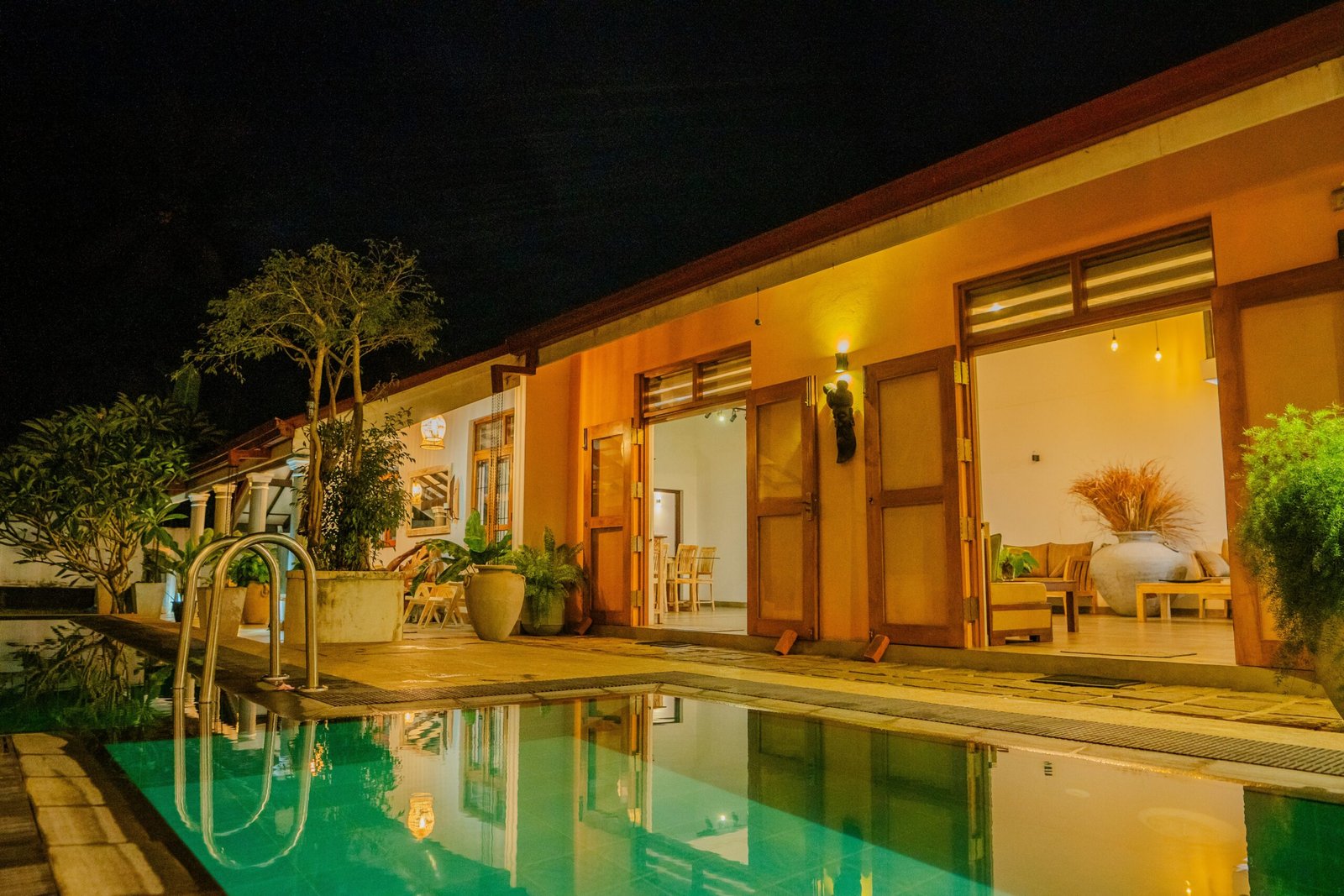 Beautifully lit villa with a tranquil swimming pool in Dankotuwa, Sri Lanka, creating a luxurious and peaceful setting for an ayurveda retreat.