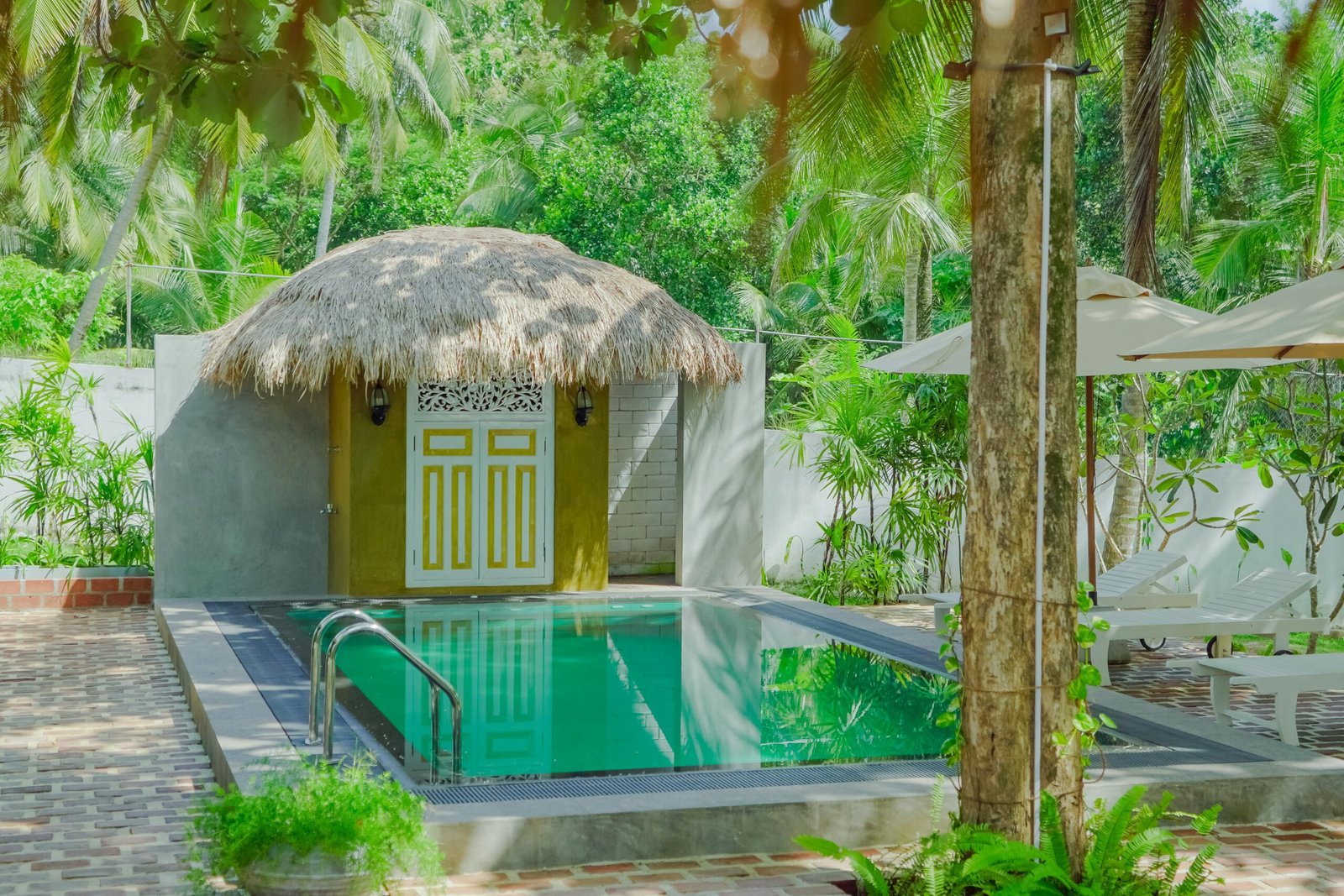 Swimming pool beside a hut in a tropical setting, matching the relaxed and restorative feel of a retreat escape.