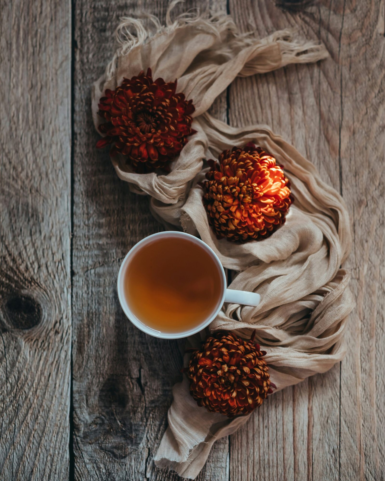 Cup of tea with dried flowers on wood capturing the cozy mood of an autumn retreat