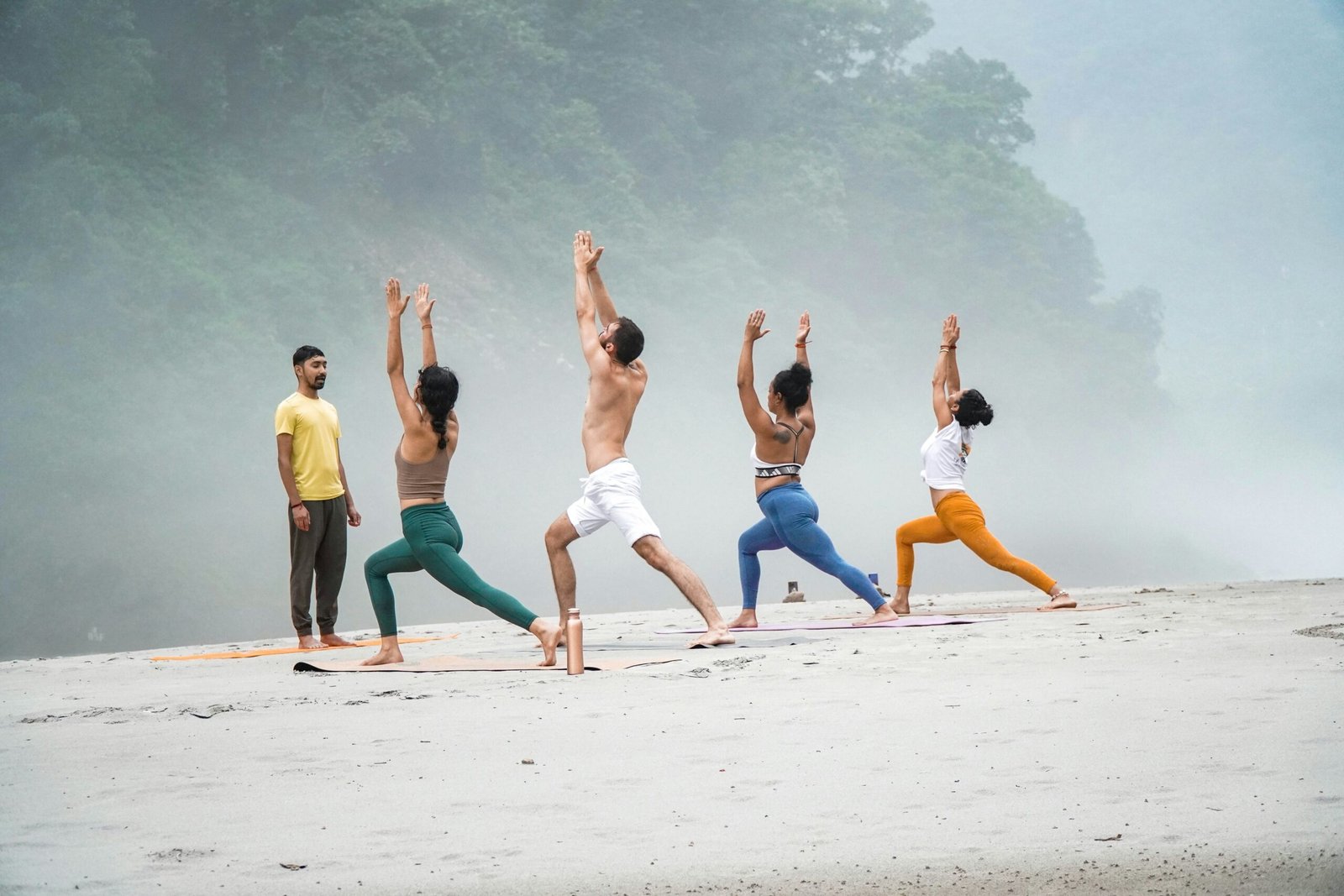 Small group practicing beach yoga during a quiet Thailand summer retreat