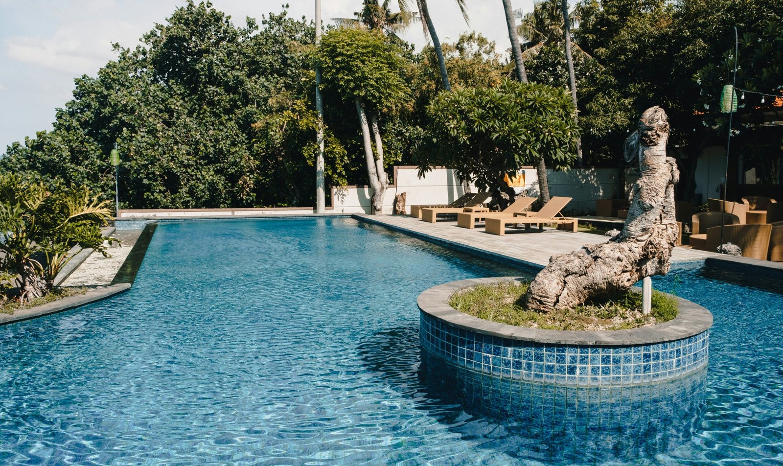 Calm resort pool with a central statue in a quiet retreat courtyard