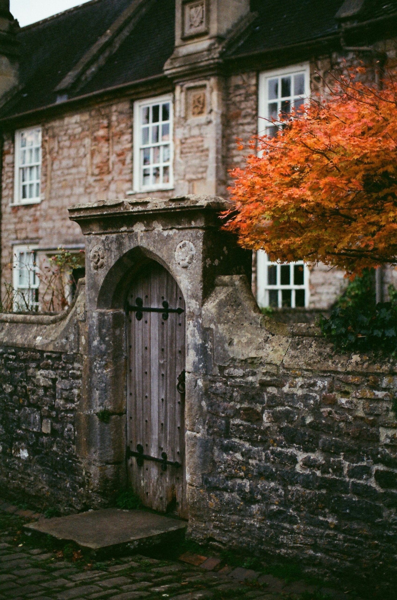 Charming stone house with autumn leaves and rustic detail, fitting the cozy atmosphere of an autumn Ayurveda retreat