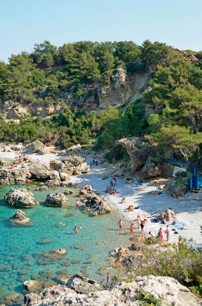 Group of people gathered on a beach beside the water, capturing the shared and uplifting atmosphere of a coastal retreat. I couldn’t verify the exact location from the photo page.