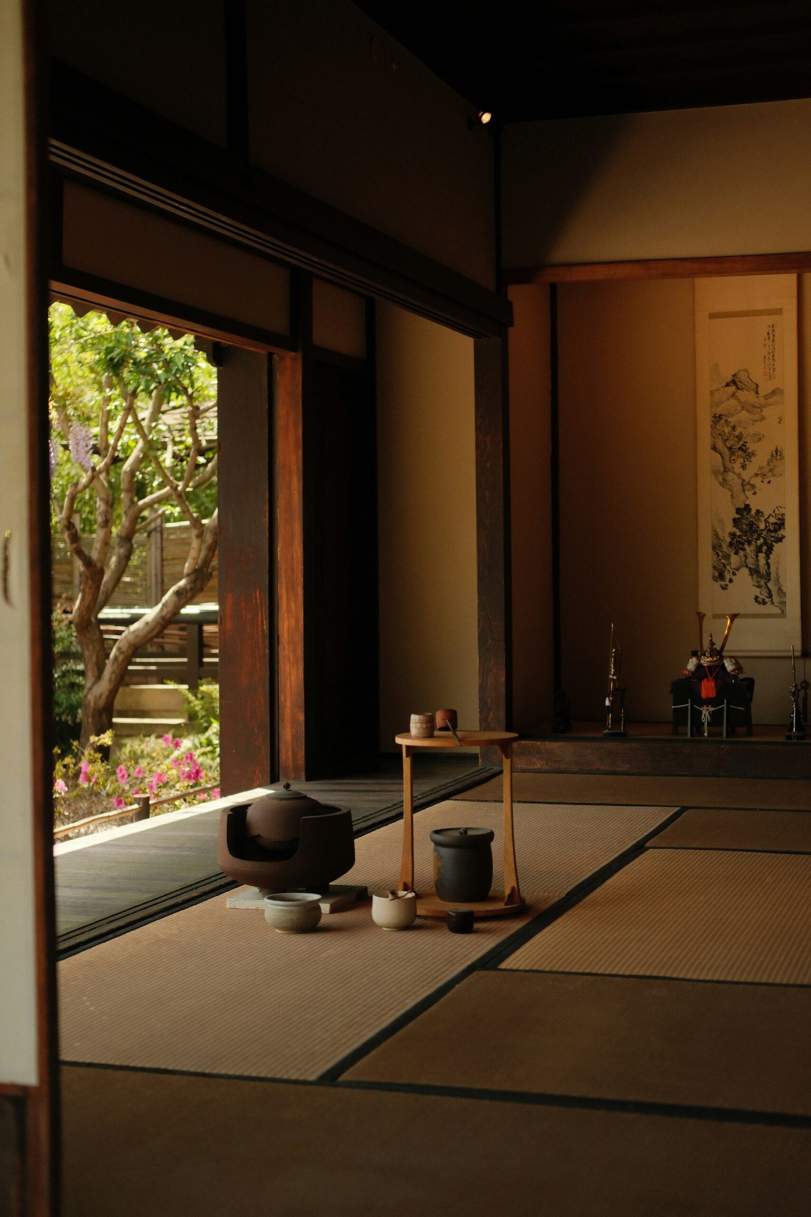 Serene Japanese tea room with open doors overlooking a peaceful garden setting.