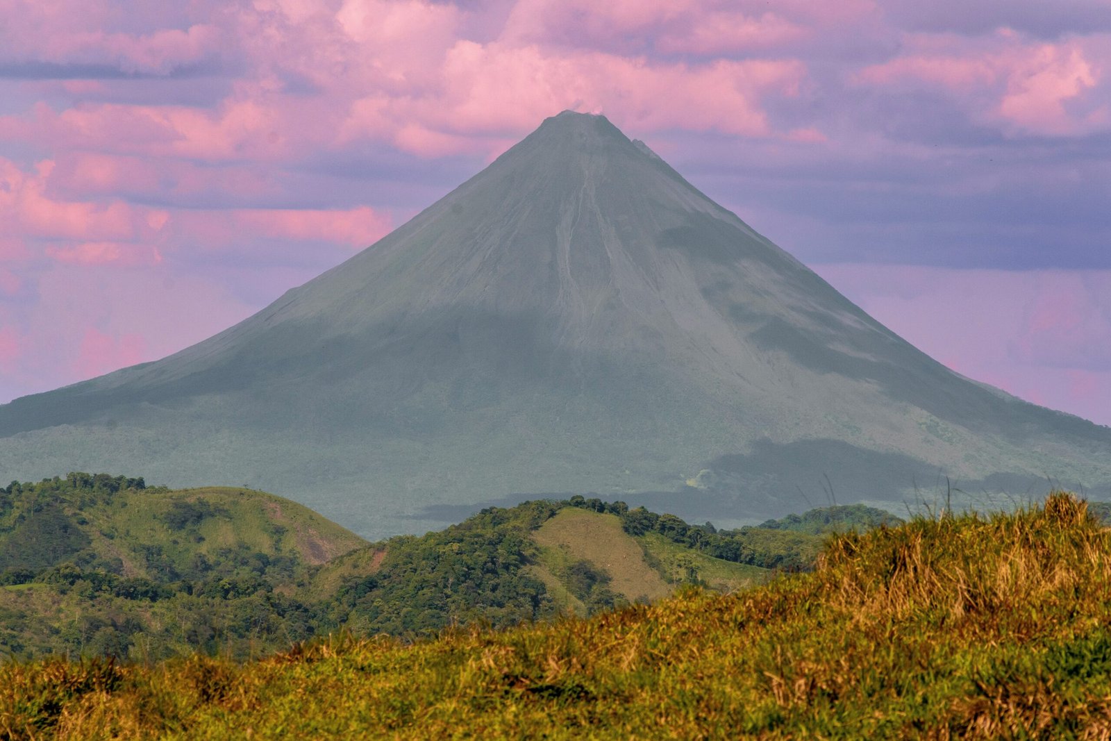 Moody evening view of Arenal Volcano above the green hills of San Carlos, Costa Rica.