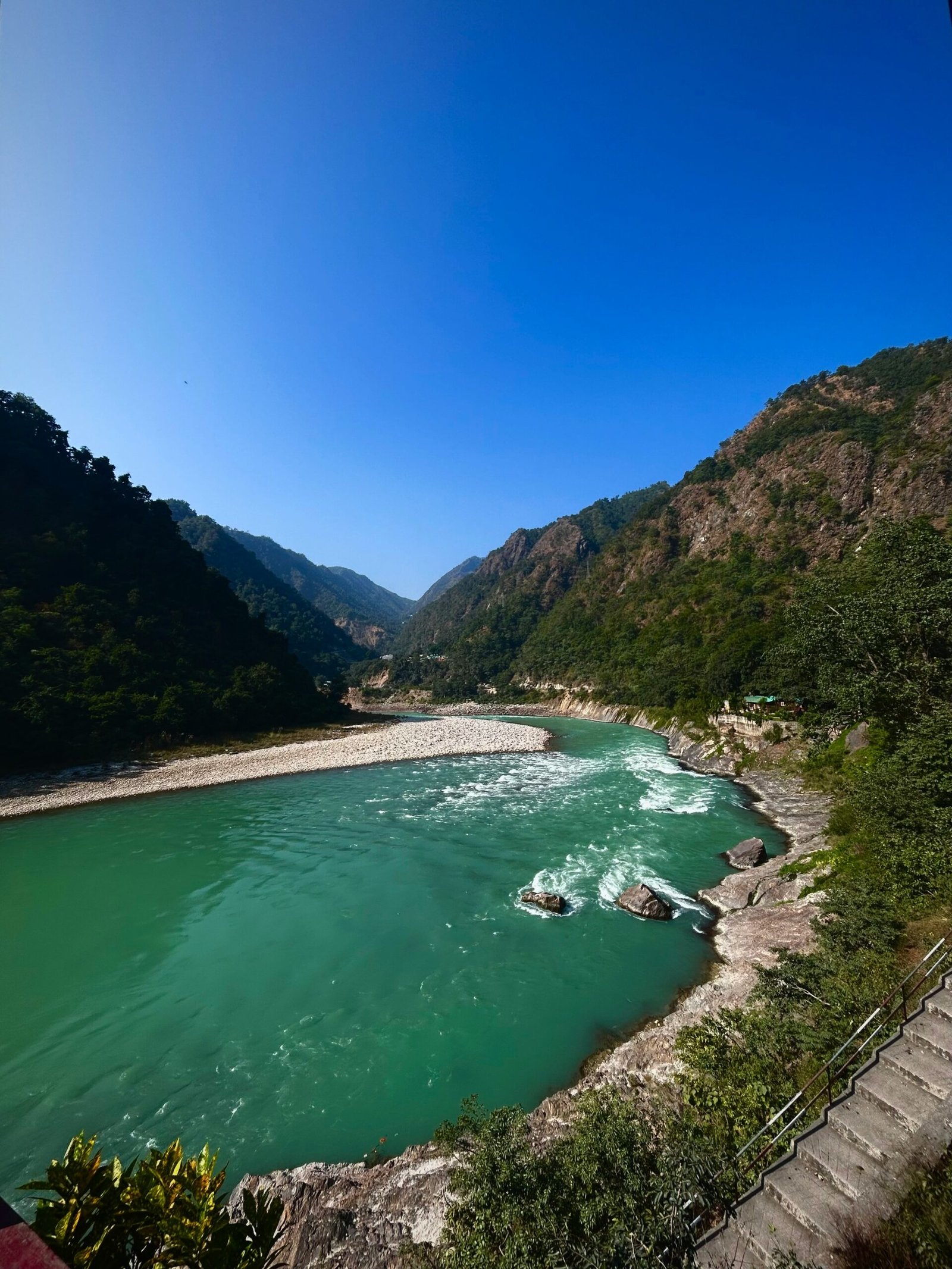 Ganges River flowing through the hills near Rishikesh, creating a spiritual and grounding setting for a yoga retreat in India.