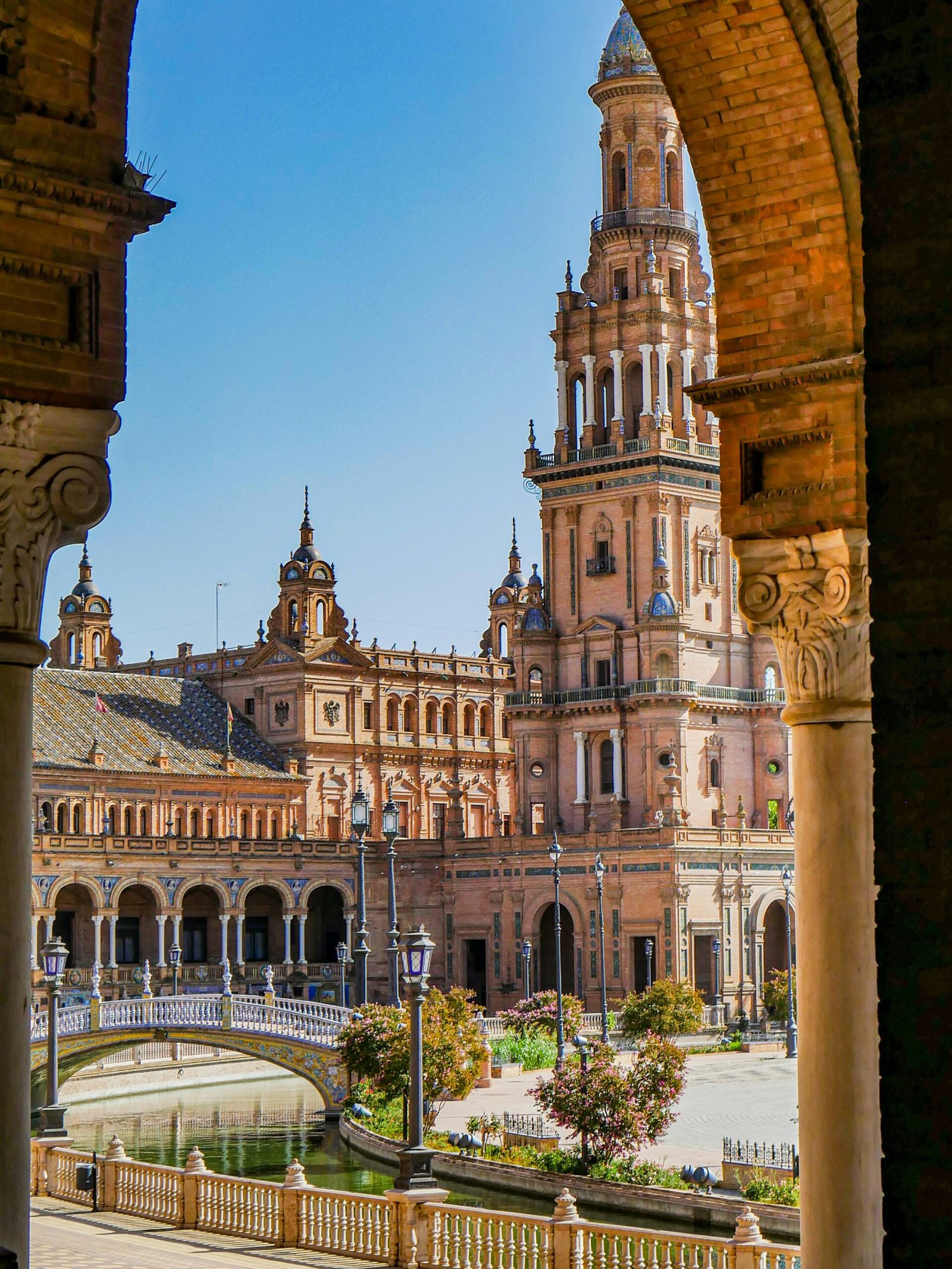 Plaza de España in Seville, Spain, with the canal bridge leading toward the grand semicircular building.