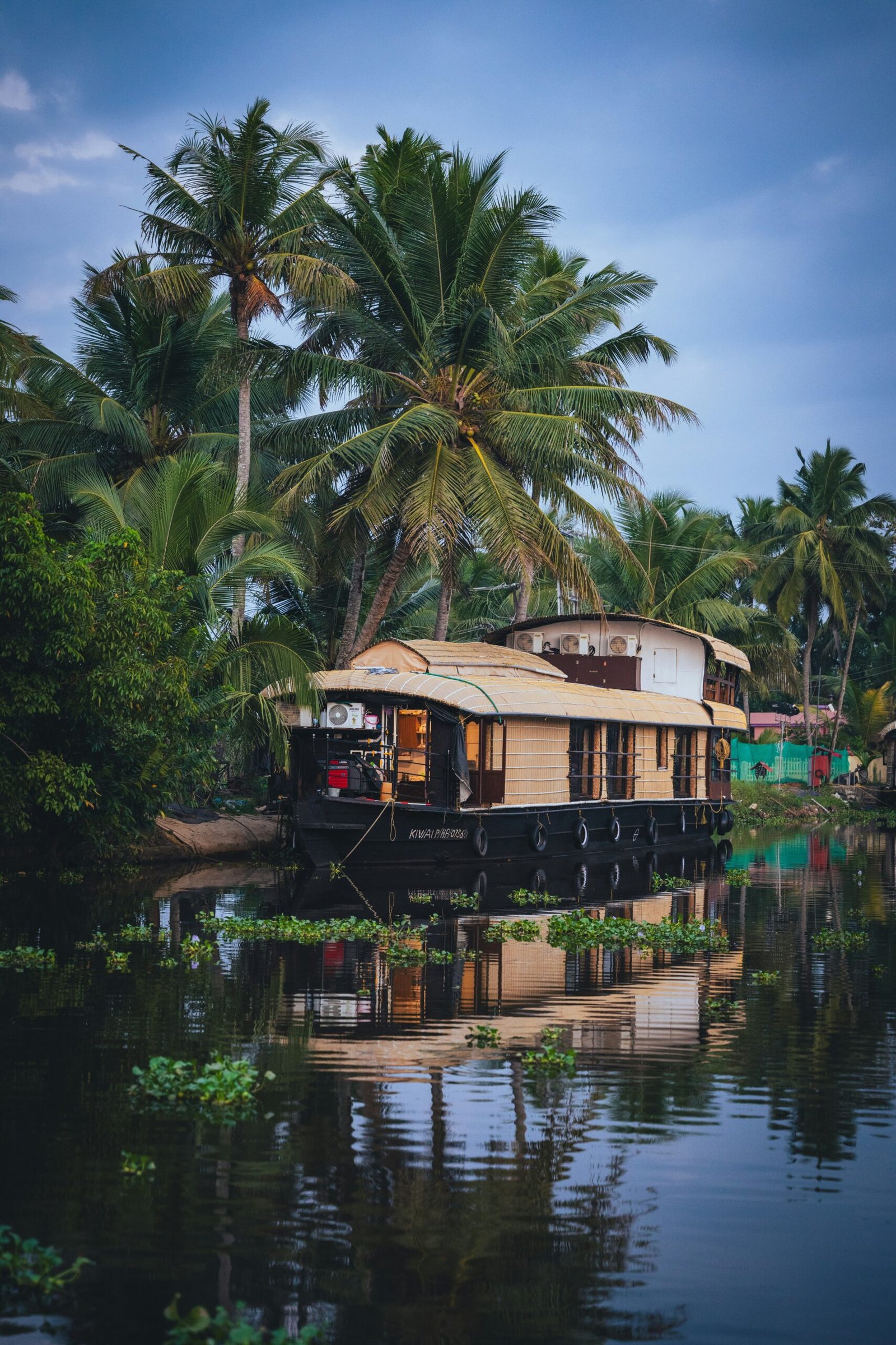 Houseboat resting on the Kerala backwaters, suited to the peaceful rhythm of a winter yoga retreat in southern India.