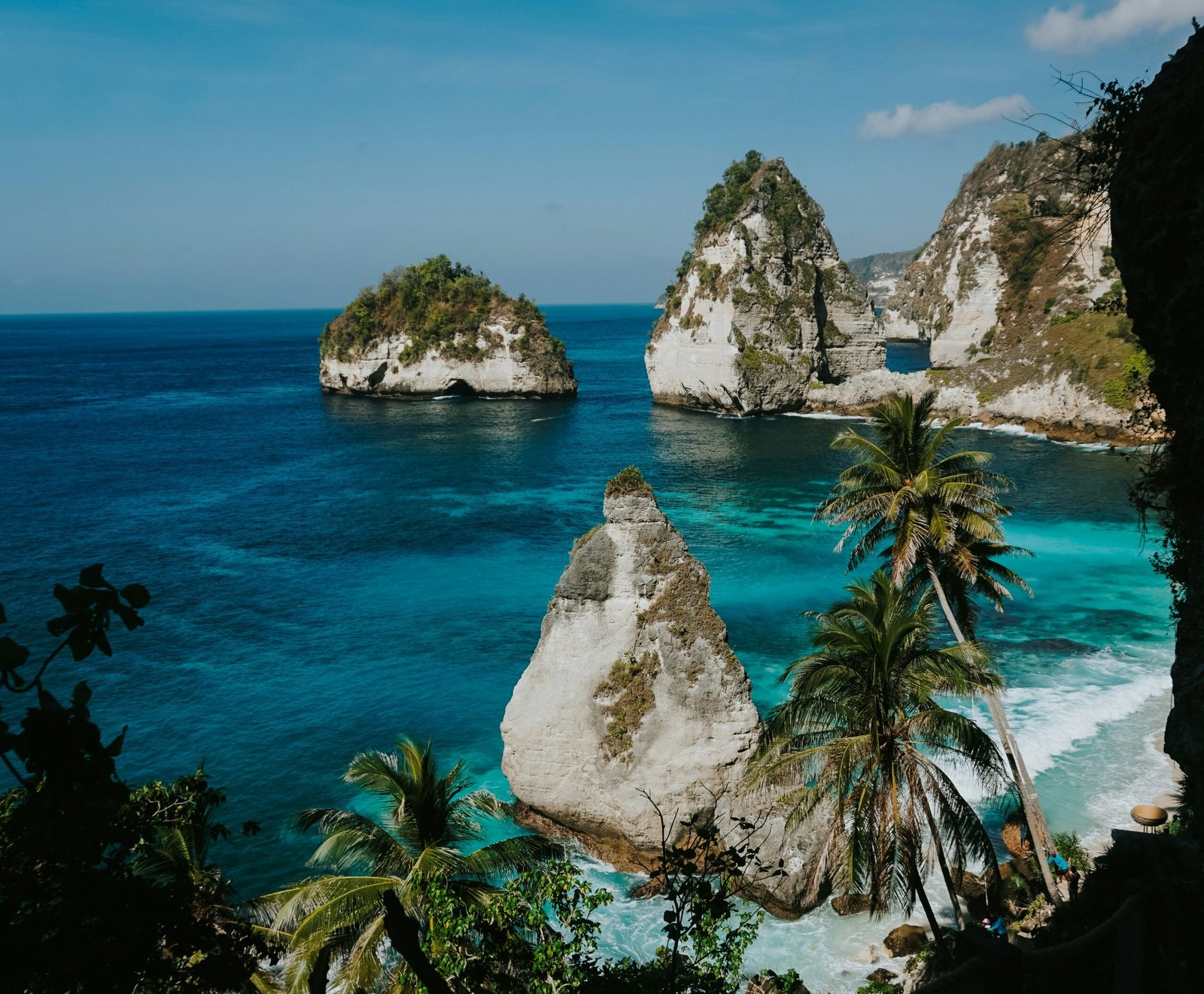 Tropical island cliffs above clear blue water for a summer retreat focused on nature, openness, and reset