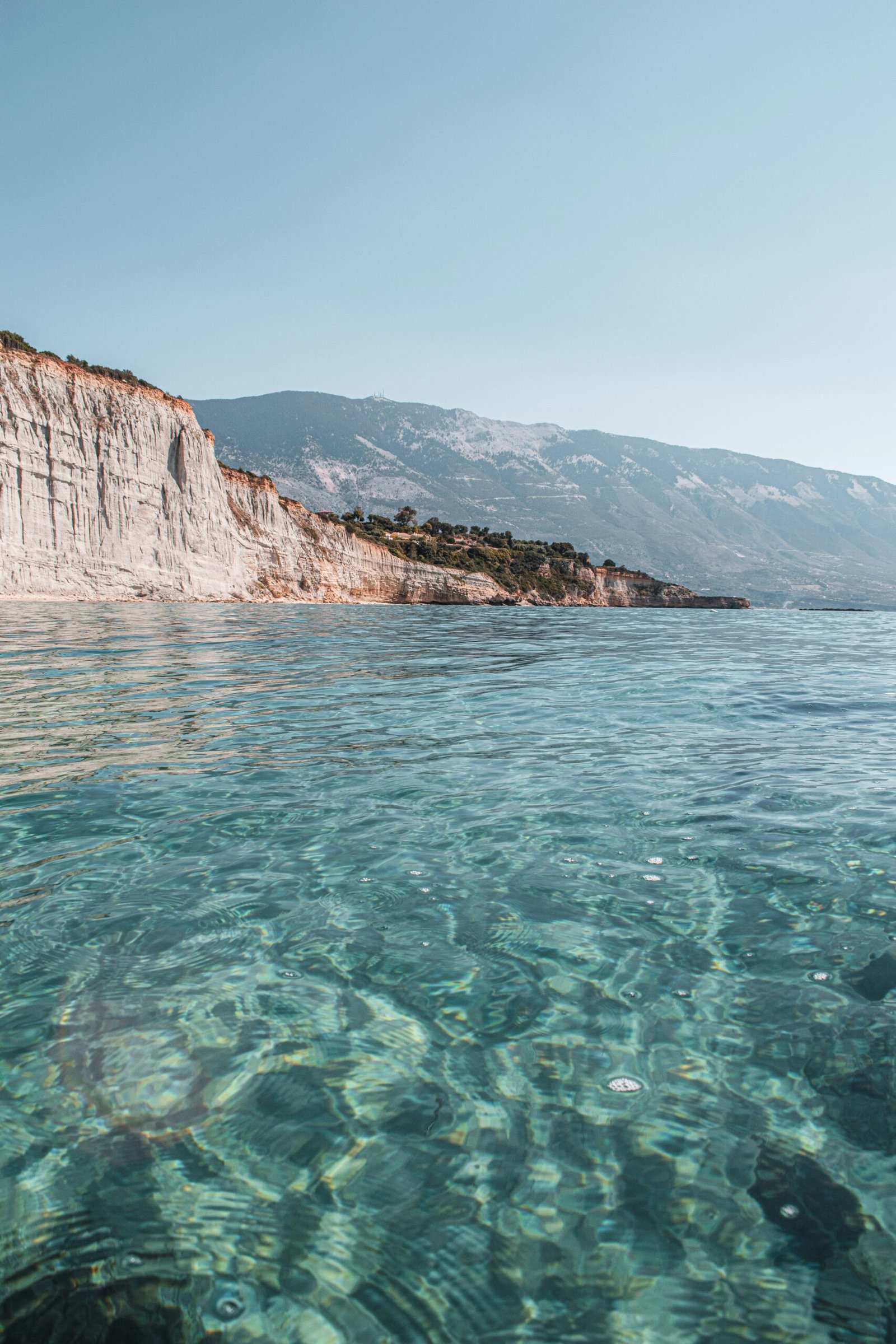 Rocky coastal cliffs and calm sea in Kefalonia, Greece, creating a secluded island retreat setting.