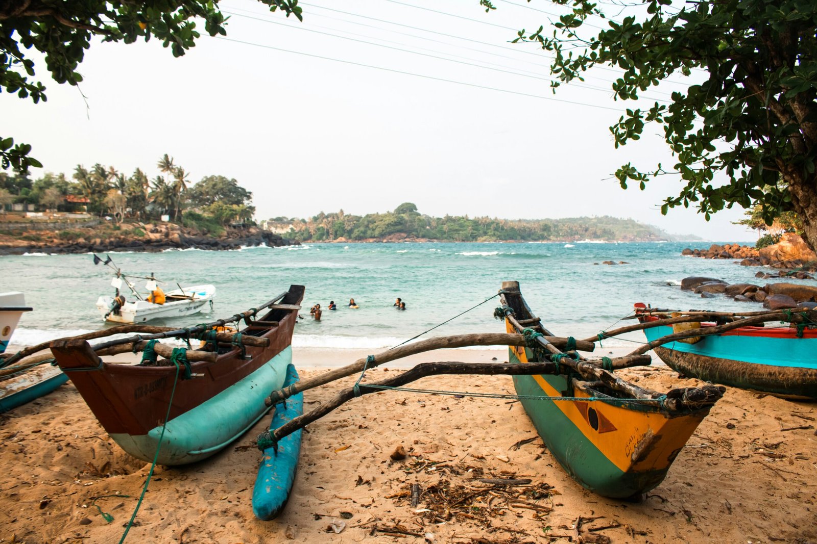 Boats resting on a sandy Sri Lanka beach with open ocean behind them, creating a calm coastal setting for an ayurveda retreat.
