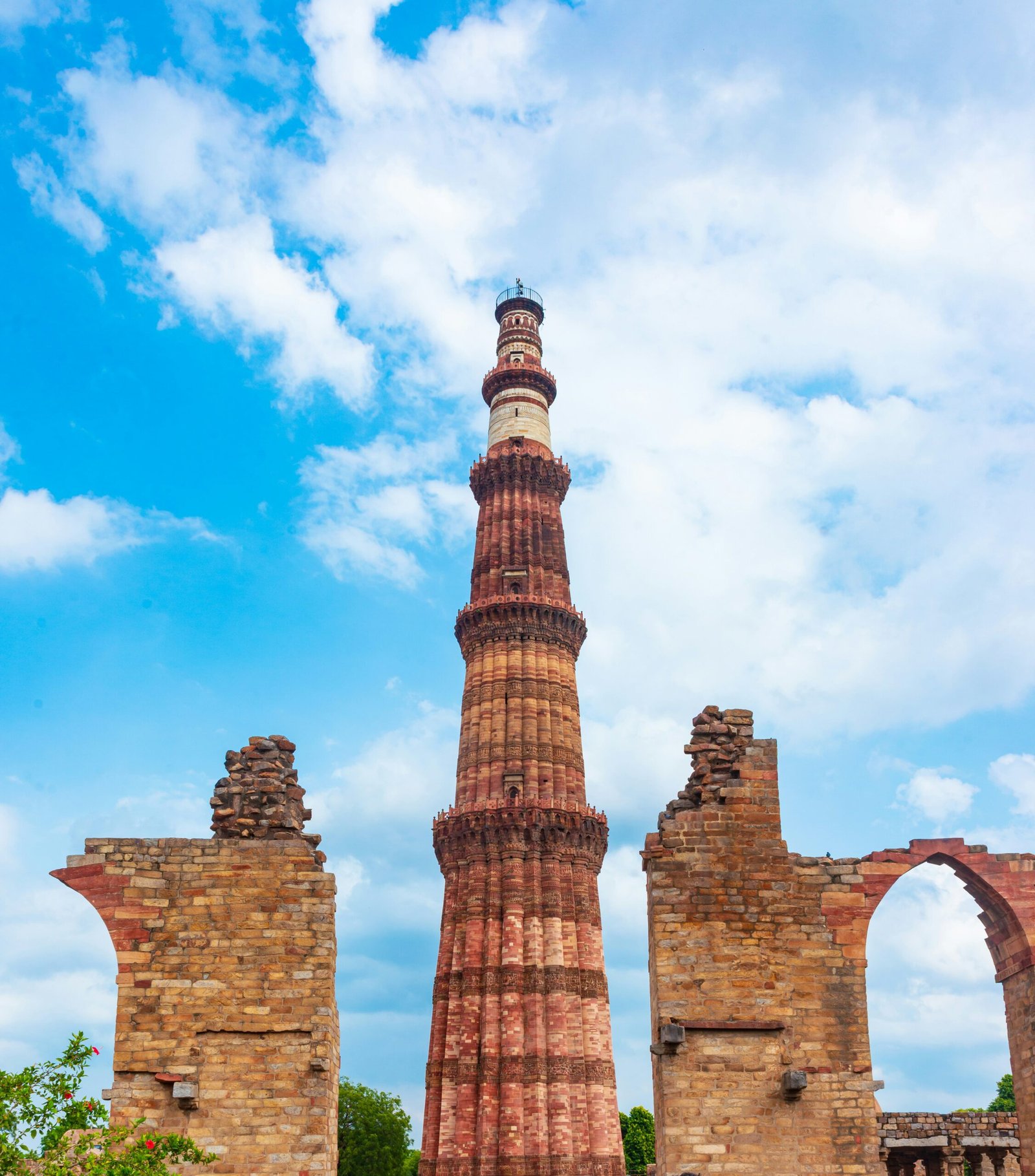 Qutub Minar rising against a clear blue sky in Mehrauli, bringing a cultural and contemplative backdrop to a retreat-themed article about India.
